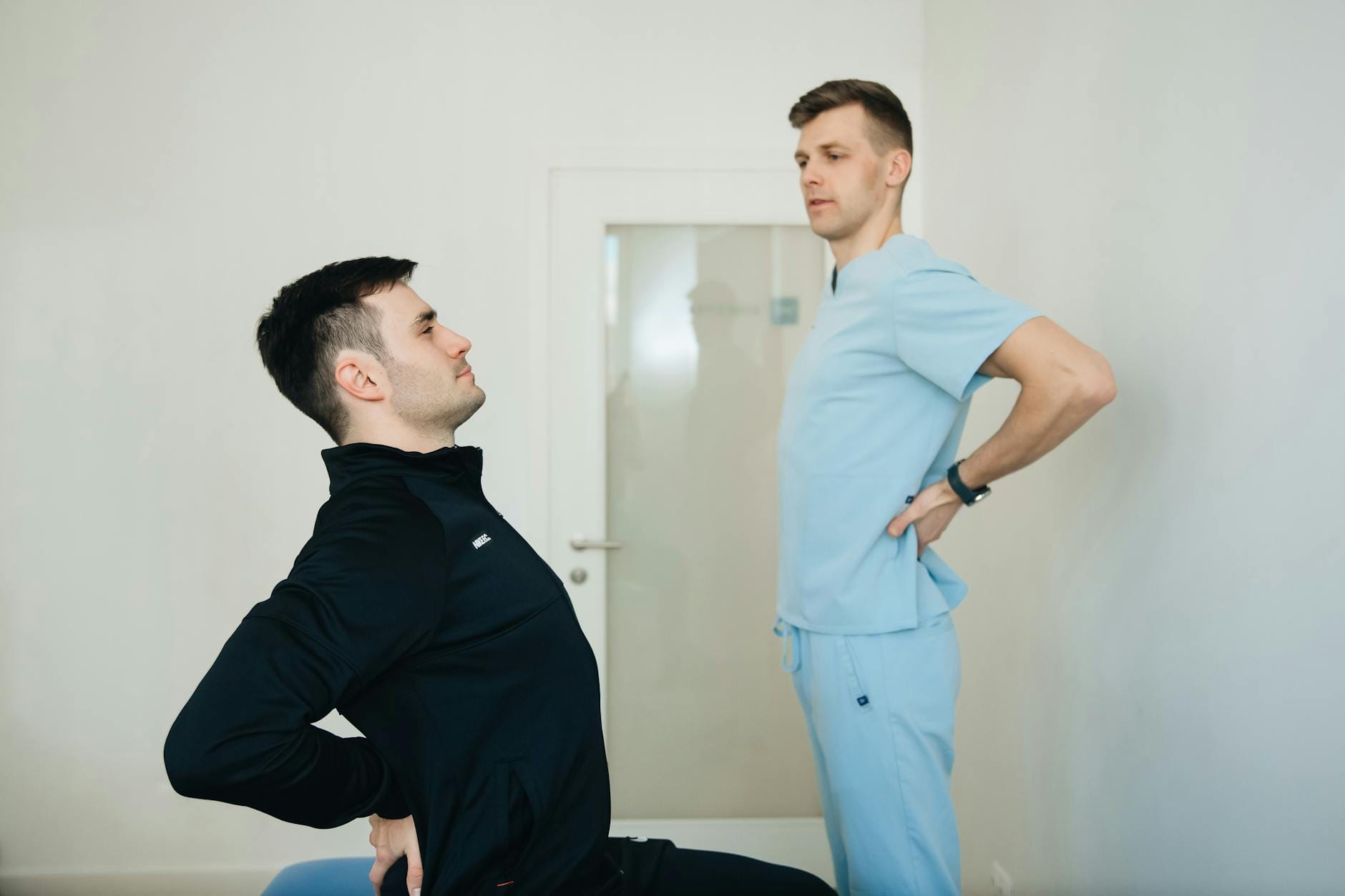 Fizjoterapeuta pokazuje pacjentowi proste ćwiczenia na ból kręgosłupa