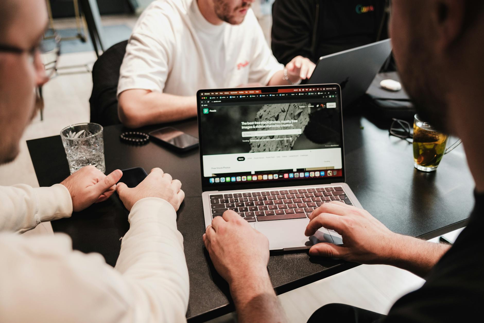 Zespół pracowników IT omawia projekt przy laptopach w nowoczesnym biurze